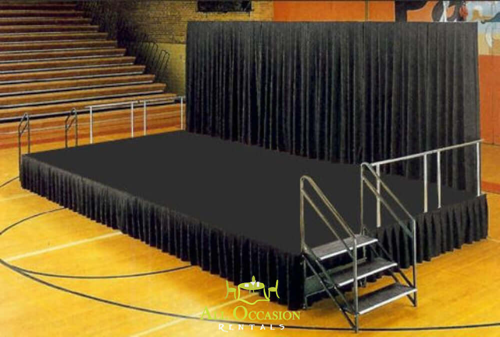 12' X 16' Stage set up in a gym with black drapes and steps for easy access, ideal for events and performances.