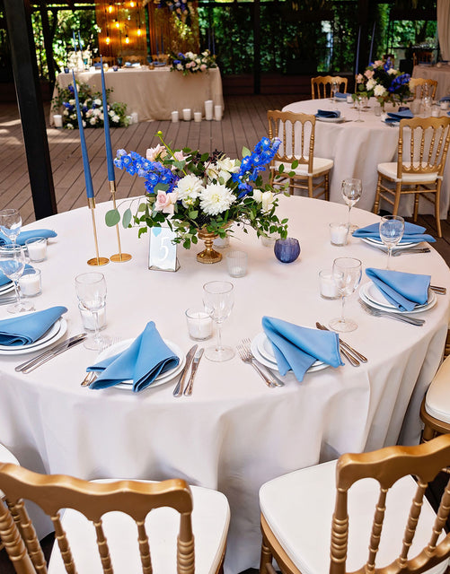 Elegant banquet table setup for event rentals in Corona with blue linens and floral centerpiece.