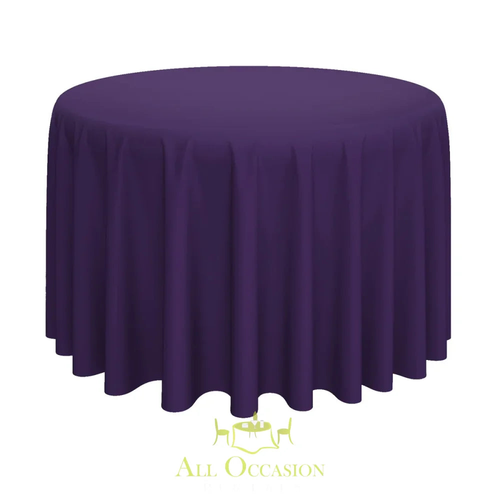 132 Inch Round Polyester Tablecloth Eggplant draped over a round table, perfect for elegant events by All Occasion Rentals.