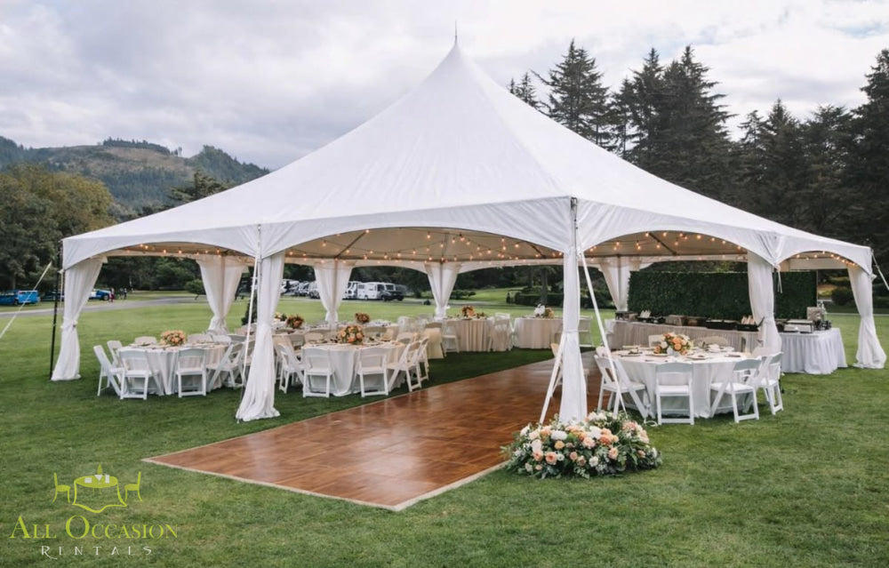 20' X 50' Quick Peak style frame tent set up for an outdoor event with tables and chairs.