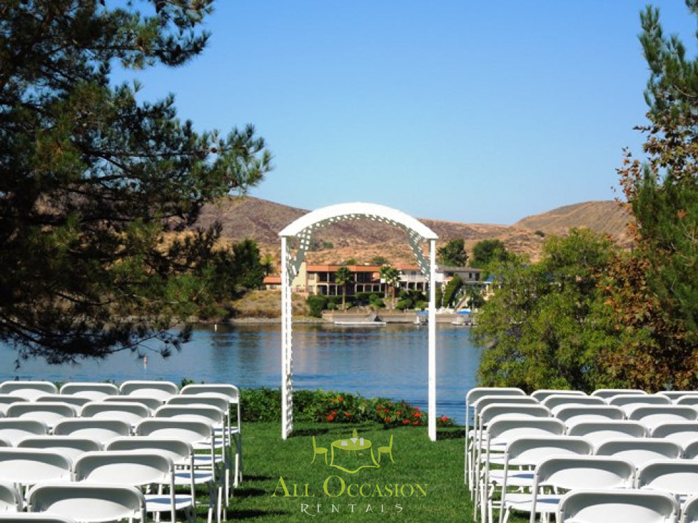 White Deluxe Lattice Arch wedding setup with chairs, ideal for Corona event rentals and outdoor ceremonies.