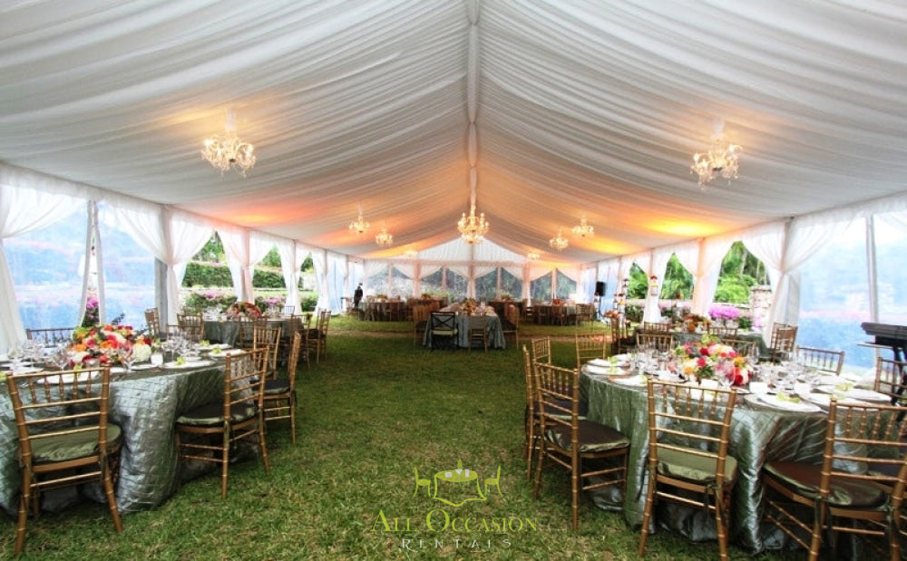 Elegant tent liner setup for events with chandeliers, banquet tables, and lush decor for rentals in Corona.