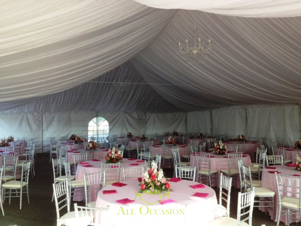 Elegant tent liners in a banquet setup with chiavari chairs and floral centerpieces for event rentals in Corona.