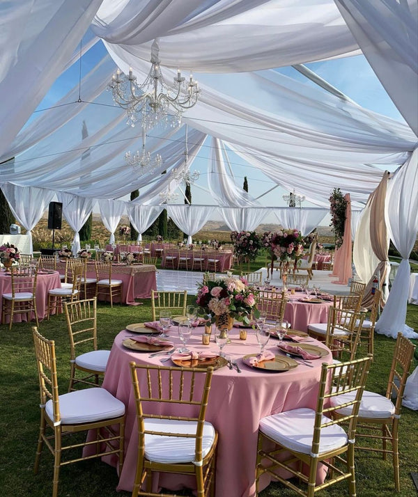 Elegant outdoor event setup featuring a pink table with chandelier, perfect for Corona event rentals and wedding accessories.