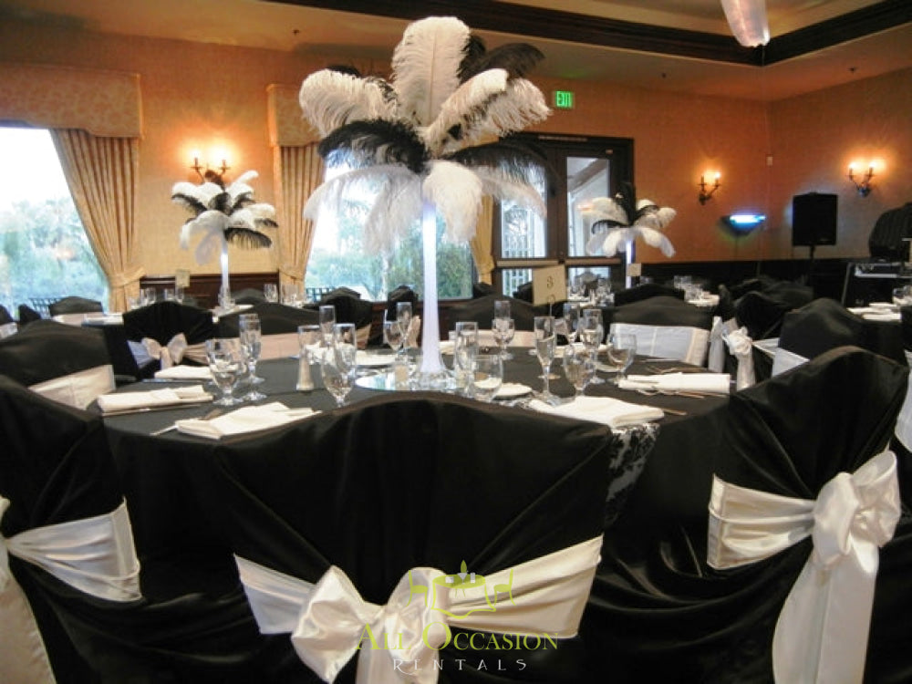 Feather centerpieces on banquet tables with black and white decor for Corona event rentals.