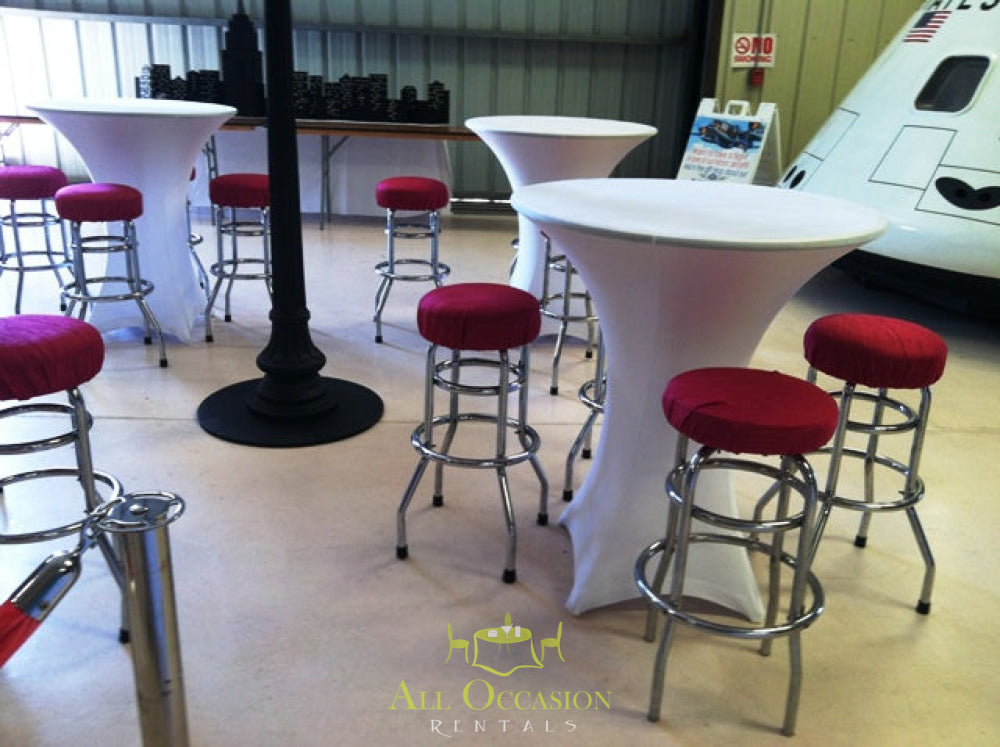 Elegant spandex cocktail tables with red stools for event rentals in Corona, ideal for parties and celebrations.