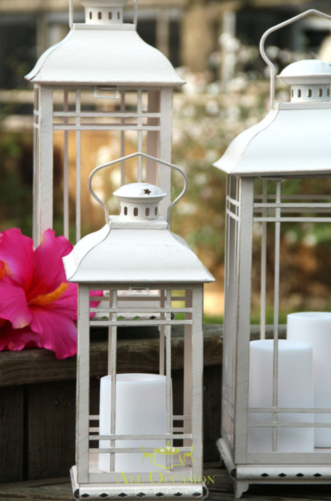 White metal lanterns for outdoor decor, perfect for event rentals in Corona, enhancing wedding and party atmospheres.